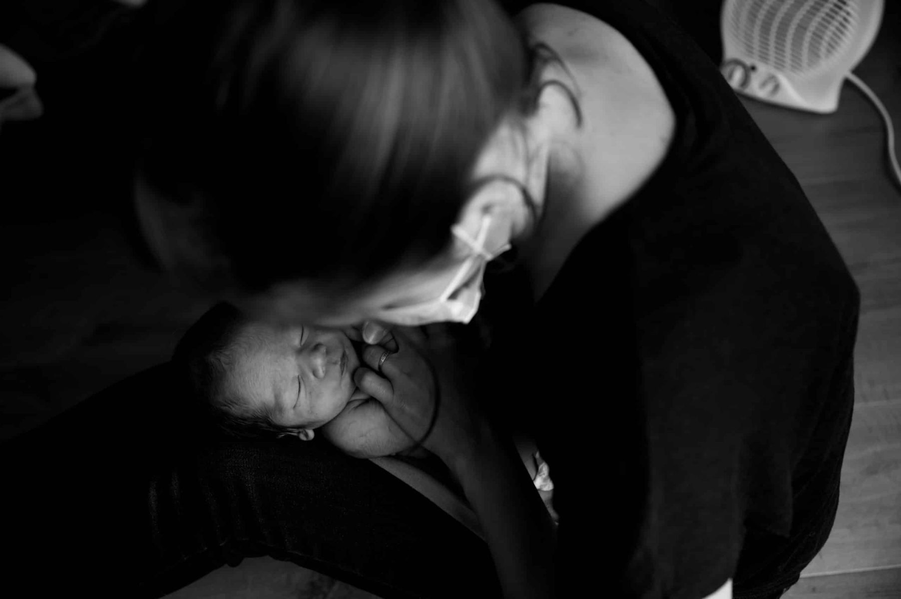 Maman embrassant son bébé en noir et blanc