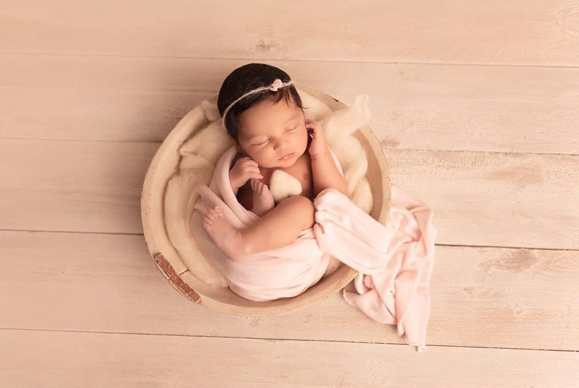 Nouveau-né endormi emmailloté dans un panier