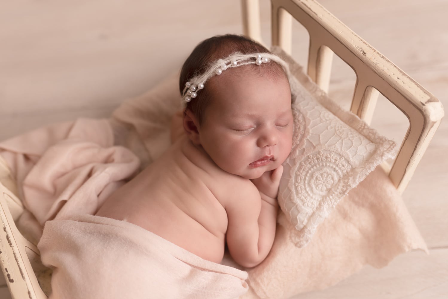Nouveau-né endormi dans un panier, bandeau en dentelle